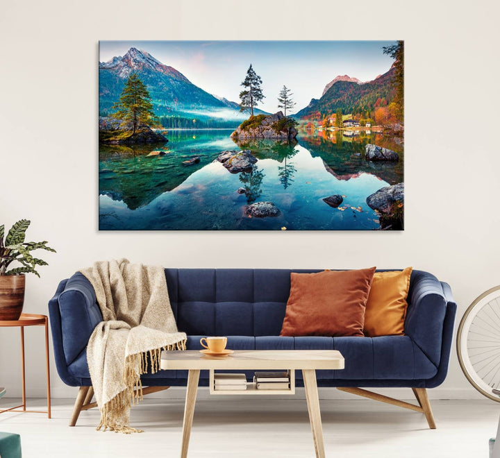 The 3-panel wall art showcases a serene mountain lake with rocky islands and trees, creating an ideal focal point for dining rooms or offices.