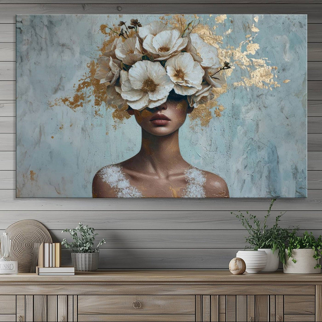 The Golden Petal Silhouette Woman Wall Art Canvas Print, a large 3-panel canvas with a textured gold floral design, serves as a luxurious centerpiece in modern glam settings. The artwork depicts a woman with flowers over her eyes against a textured background and hangs elegantly.