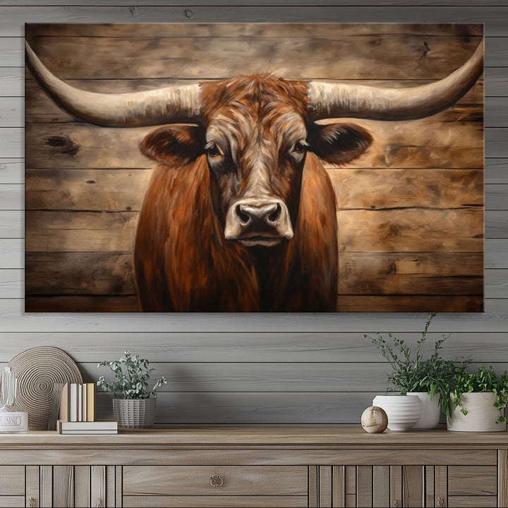 The Longhorn Bull Wall Art, a ready-to-hang canvas print, showcases an image of a brown longhorn cow set against a wooden background, perfect for those looking to enhance their space with rustic farmhouse and western barn decor.