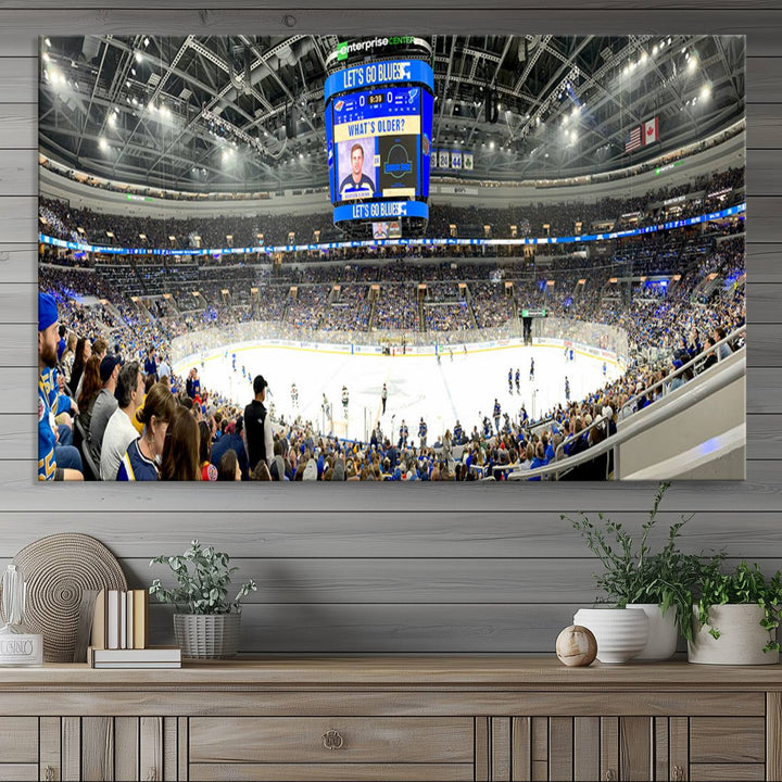 Wall art prints depicting the bustling scenes of the St. Louis Blues being cheered on by a full house at the Enterprise Center, beneath a large scoreboard.