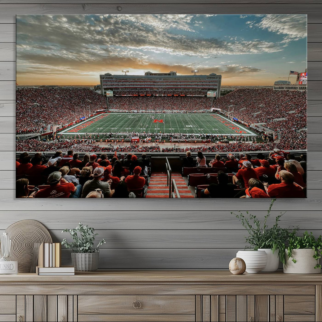 The living room features a stunning triptych of Lincoln Memorial Stadium wall art canvas print, celebrating the University of Nebraska Cornhuskers football team. This piece serves as captivating wall art, showcasing a gallery-quality finish.