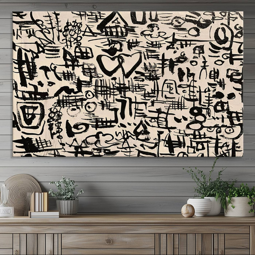 The Abstract Love and Chaos canvas is a museum-quality print featuring black symbols on a beige background, adorned with a heart and scribble design. It is framed to enhance its artistic appeal.