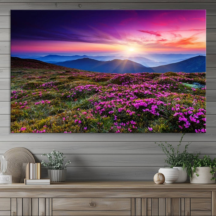 A 3-panel landscape photography canvas of a sunset over mountain meadows with purple wildflowers decorates the wall.