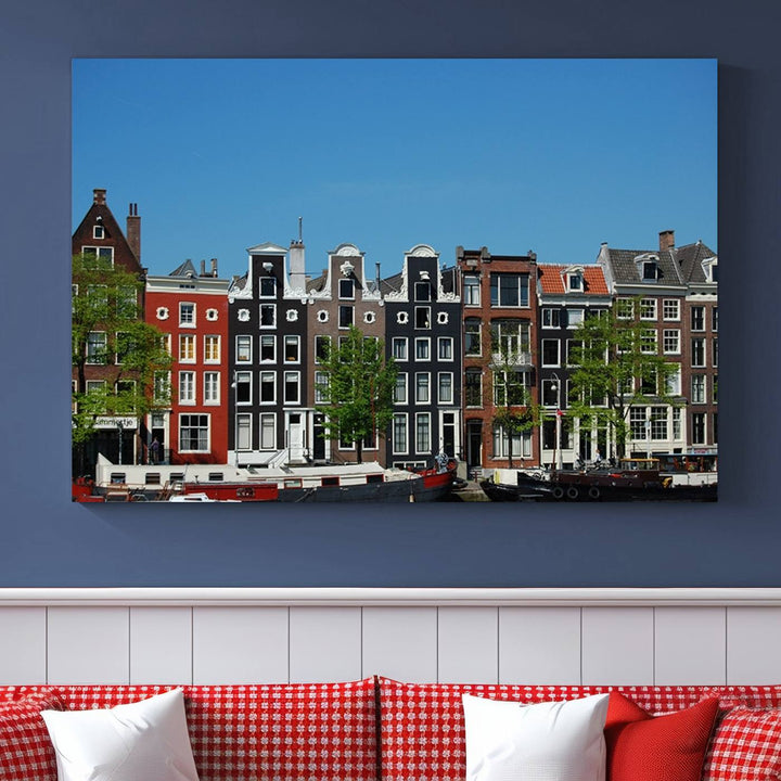 The Amsterdam City Wall Art Canvas Print showcases colorful traditional canal houses and boats set against a clear blue sky.