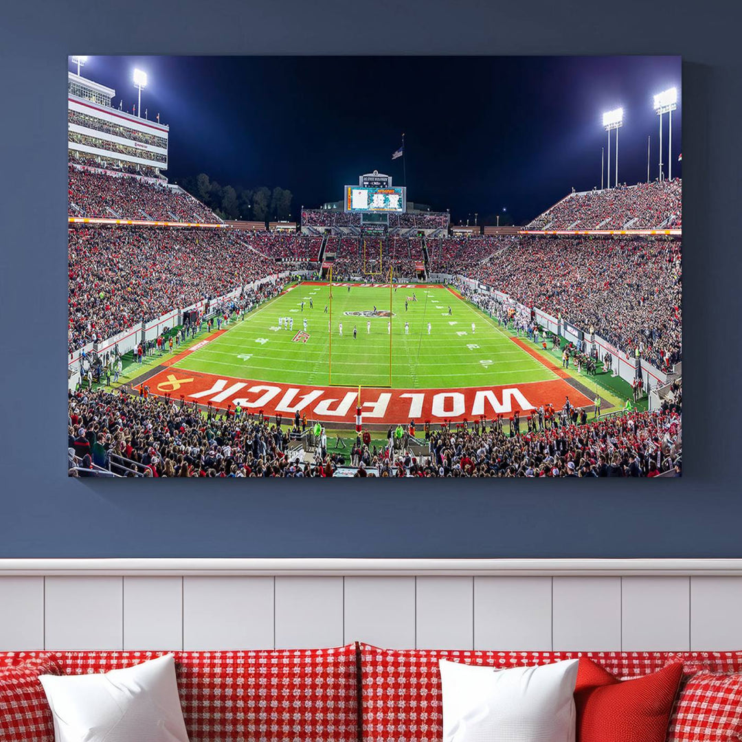 A NC State Wolfpack Football Team print of Carter-Finley Stadium at night features WOLFPACK illuminated brightly in the end zone grass.