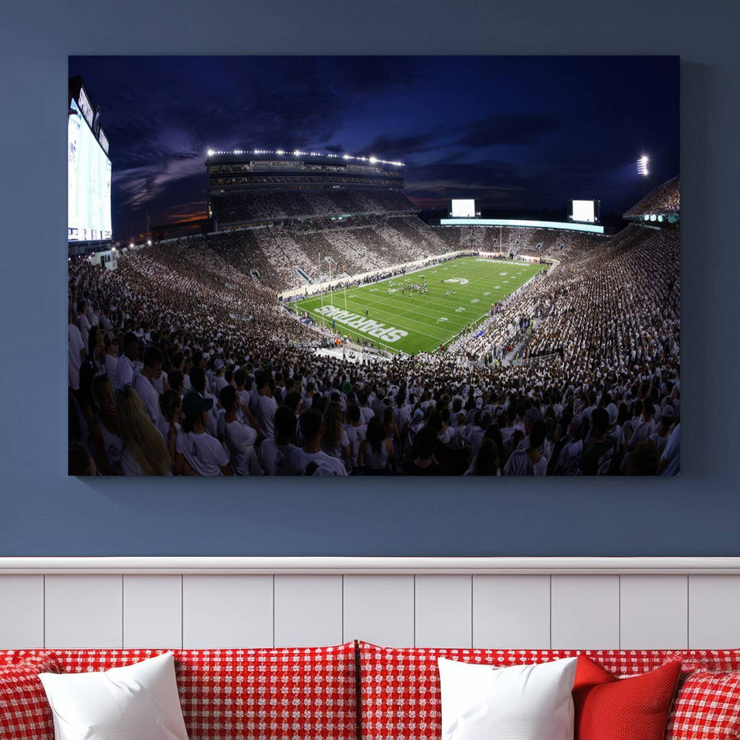 A packed football stadium at night, with bright lights and fans in white, depicted in a Michigan State Spartans Stadium wall art.