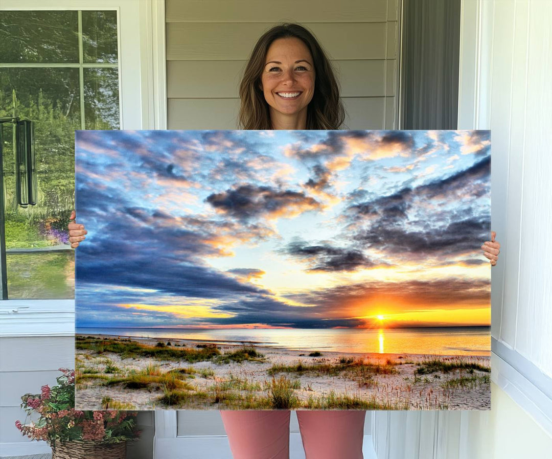 The Sunset On The Ocean canvas wall art features a beautiful beach sunset with grass and clouds.