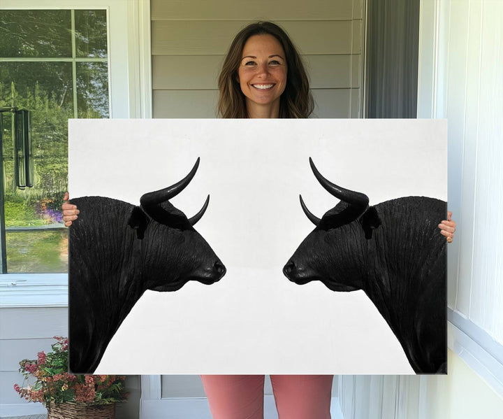 A framed canvas print featuring two black bull silhouettes, perfect for modern rustic decor.