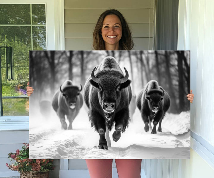 The Buffalo Wall Art Canvas Print of bison running through snow adorns the wall.