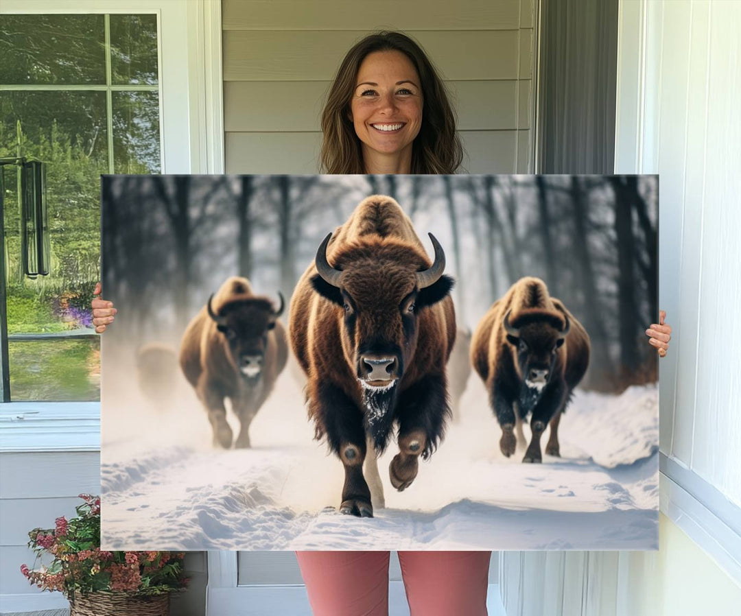 Wall art titled Cow Bighorn shows three bison running through snow in a forest.