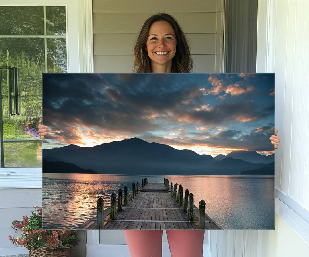 The Mountain Lake Wood Pier Canvas Wall Art depicts a serene lake and mountains, enhancing the beauty of any space.