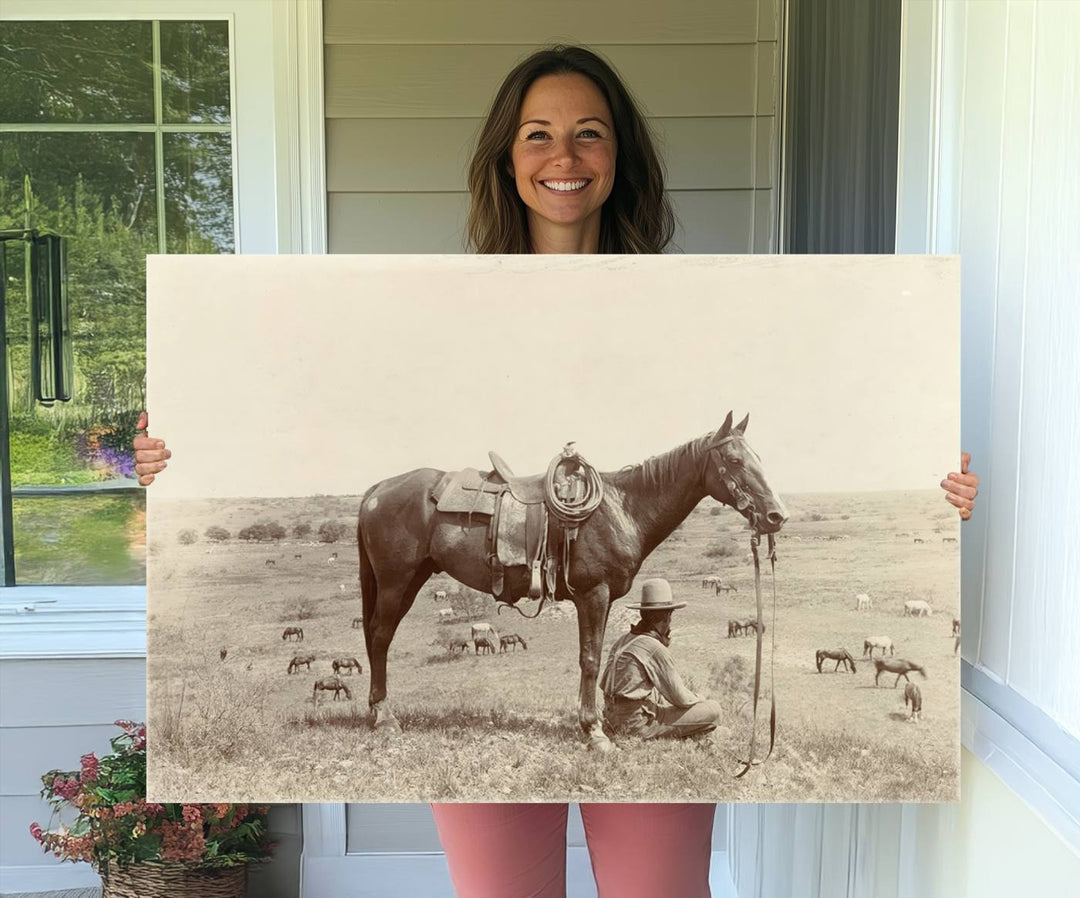 Cowboy Wall Art - Vintage Western Horse Canvas Print features a cowboy kneeling by his horse in a field.