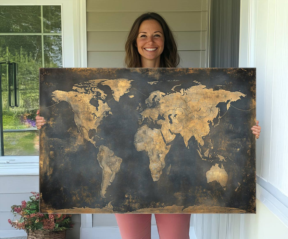 The Grunge World Map Canvas Wall Art features golden tones and is displayed against a white-paneled wall.