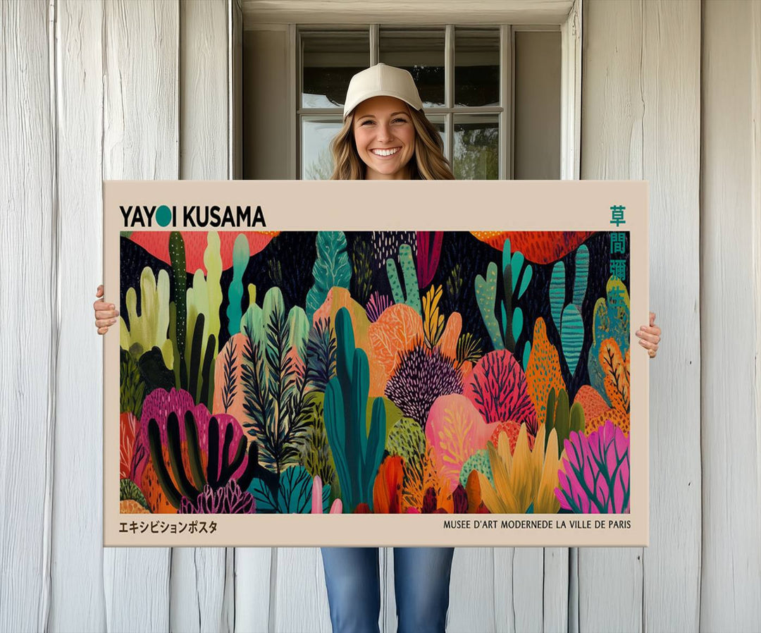 The vibrant canvas print of wall art features abstract plants, with the elegant text "Yayoi Kusama Wall Art Canvas Print" displayed on the colorful frame.