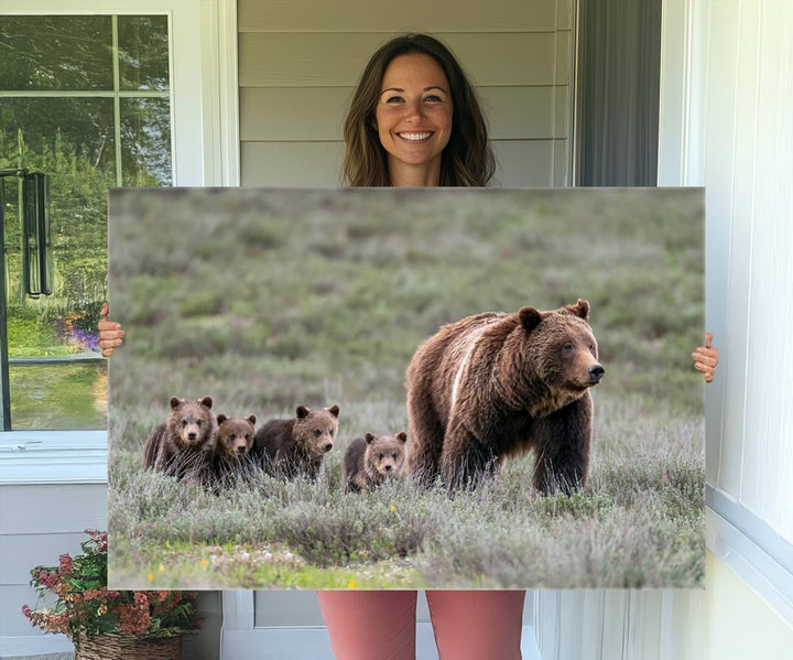 The large canvas print titled "Queen of the Tetons, 399 Grizzly Bear Cubs" showcases majestic wildlife photography of a bear and her cubs walking through the grass. This stunning canvas wall art, handmade in the USA, adds a charming touch to any room with its rustic decor appeal.