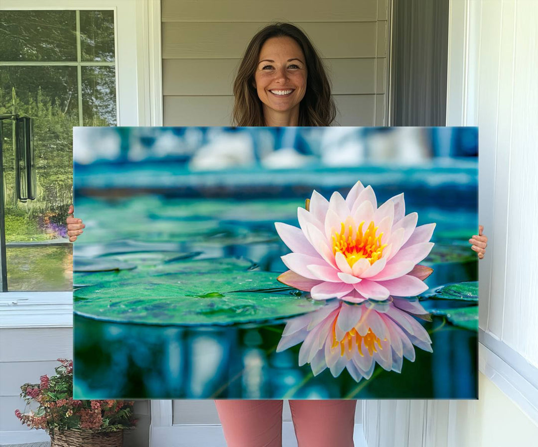 The Lotus Flower Canvas Print showcases a pink water lily with a yellow center gracefully floating on a calm pond.