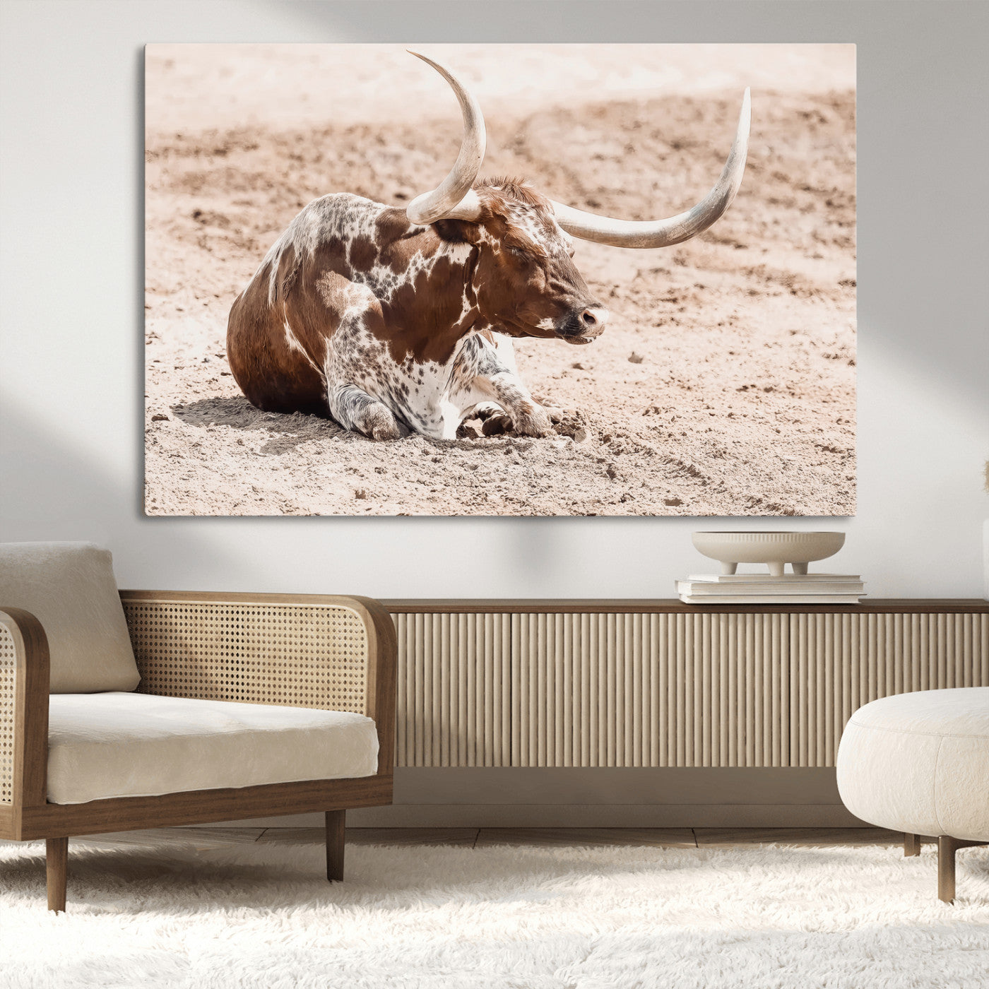 Texas Longhorn bull resting on dusty ground with warm tones, ideal for rustic western or farmhouse-themed wall decor.