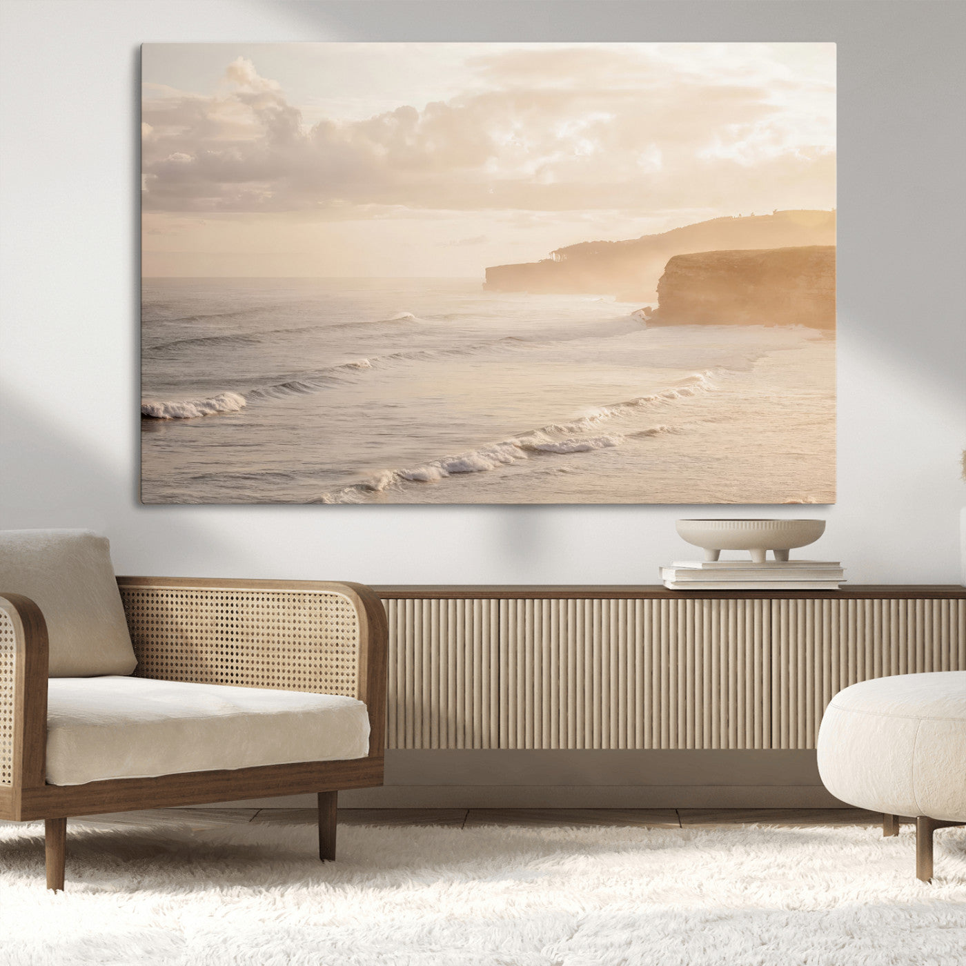 Golden hour seascape with misty cliffs and gentle waves rolling towards the shore, capturing a tranquil and warm coastal atmosphere.