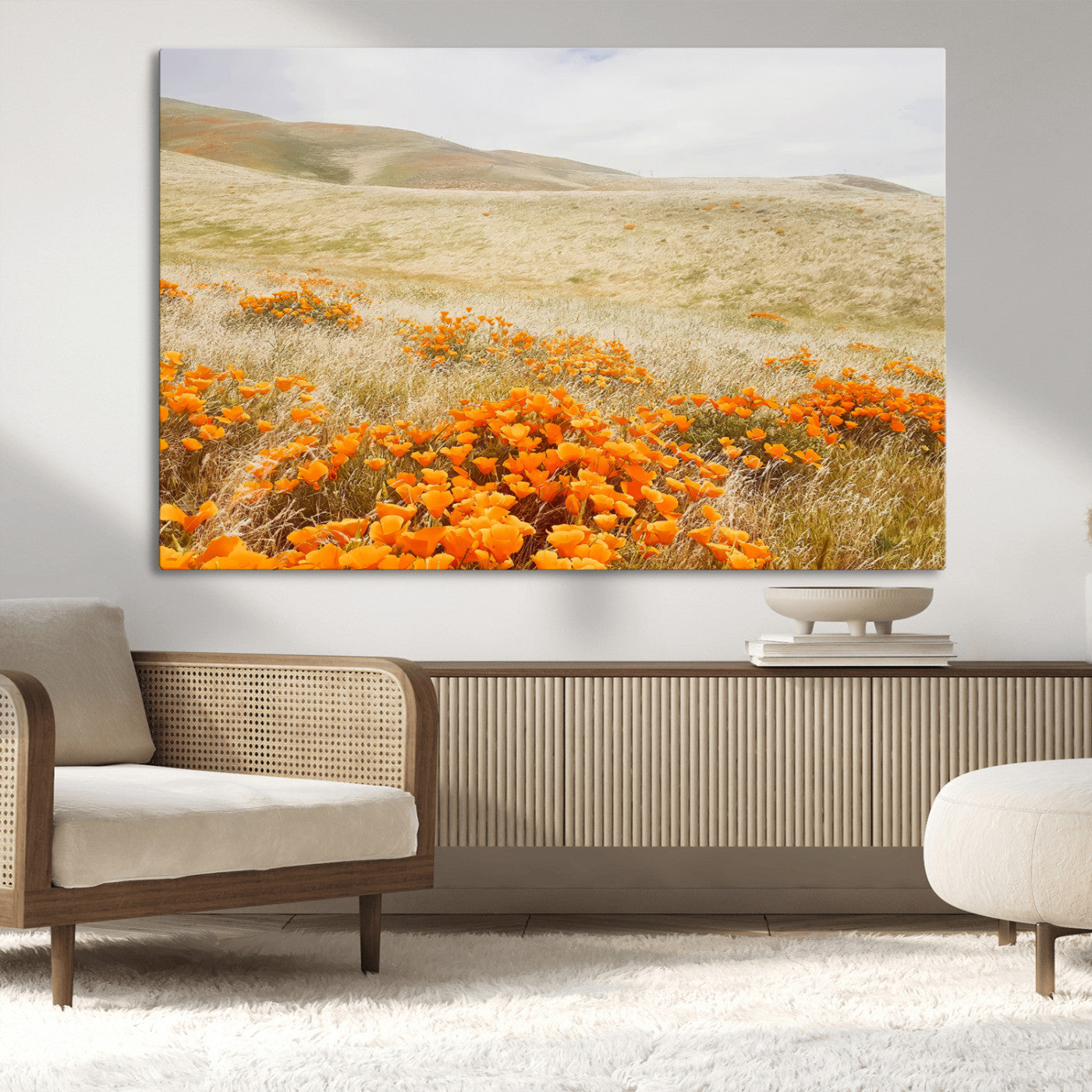 A golden field with vibrant orange poppies blooming across rolling hills under a soft, sunlit sky, creating a warm and rustic landscape.