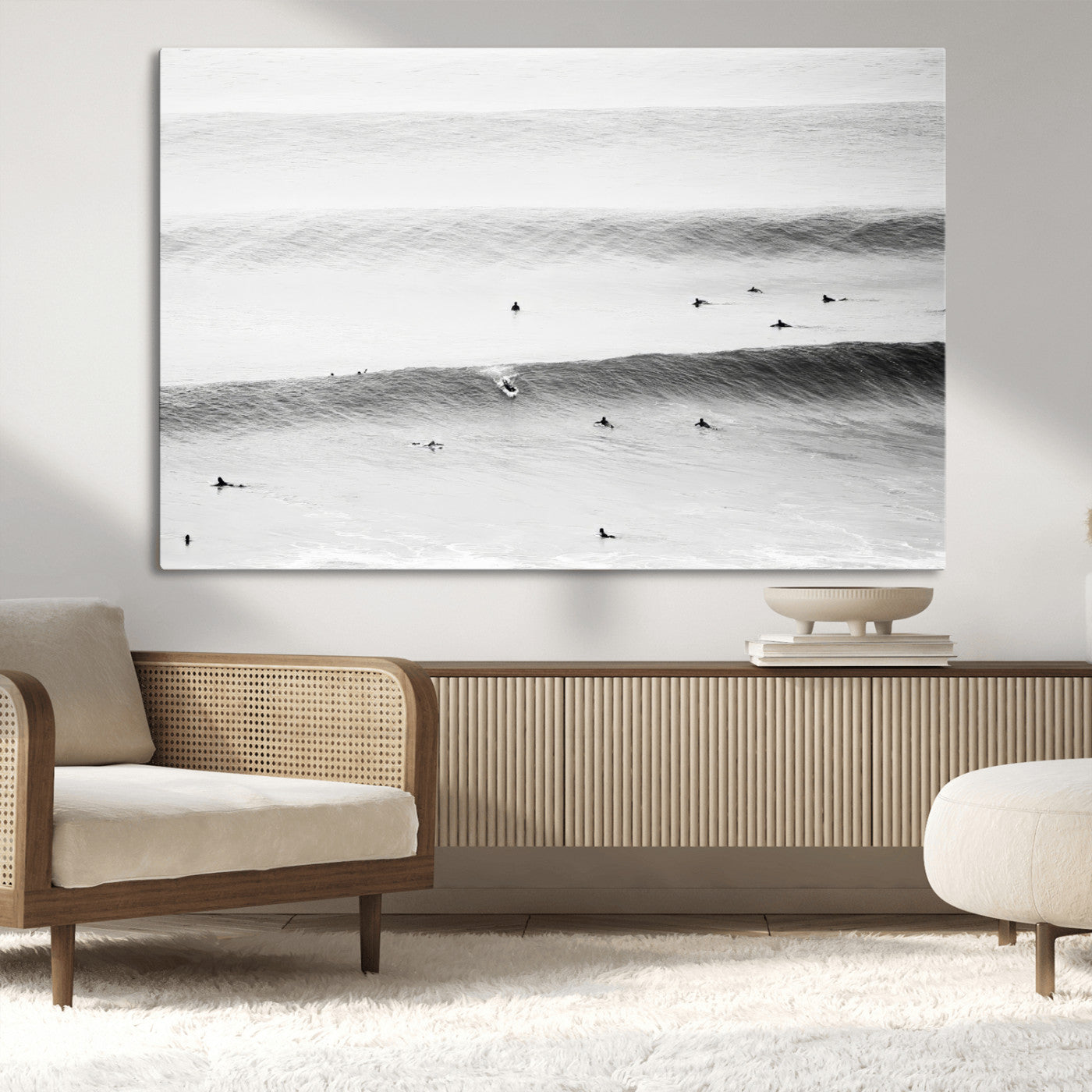 A monochrome photograph of swimmers gliding through gentle ocean waves, evoking a sense of calm and movement.