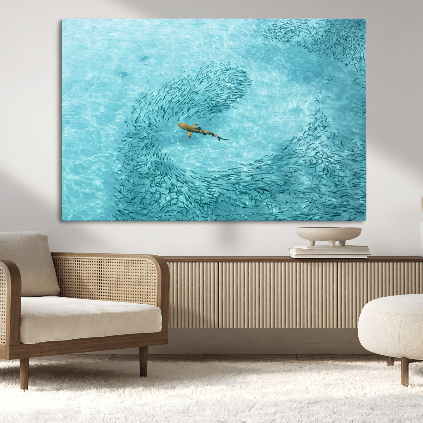 Aerial view of a shark swimming through a swirl of fish in clear turquoise waters, perfect for calm coastal or beach house decor.