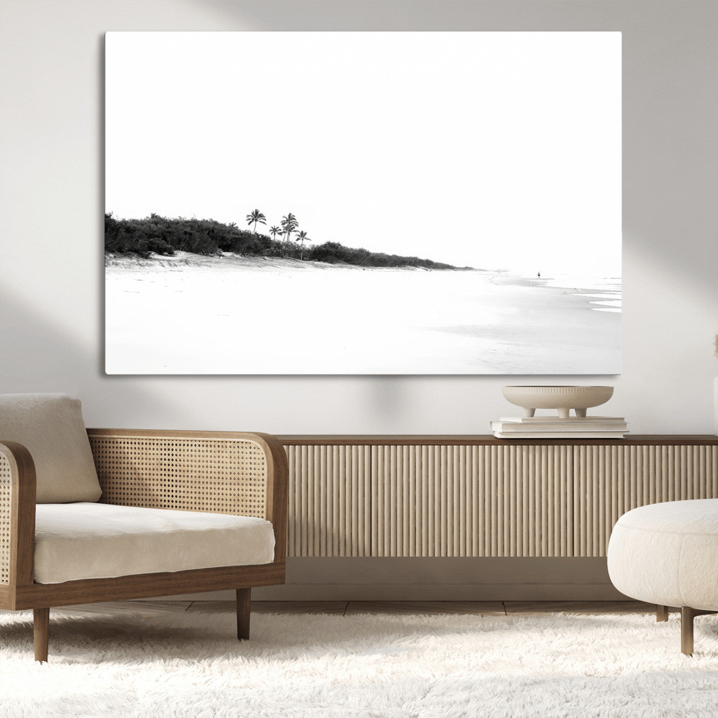 A black and white minimalist coastal scene with a vast open beach, distant palm trees, and a lone figure walking along the shoreline, evoking serenity and solitude.