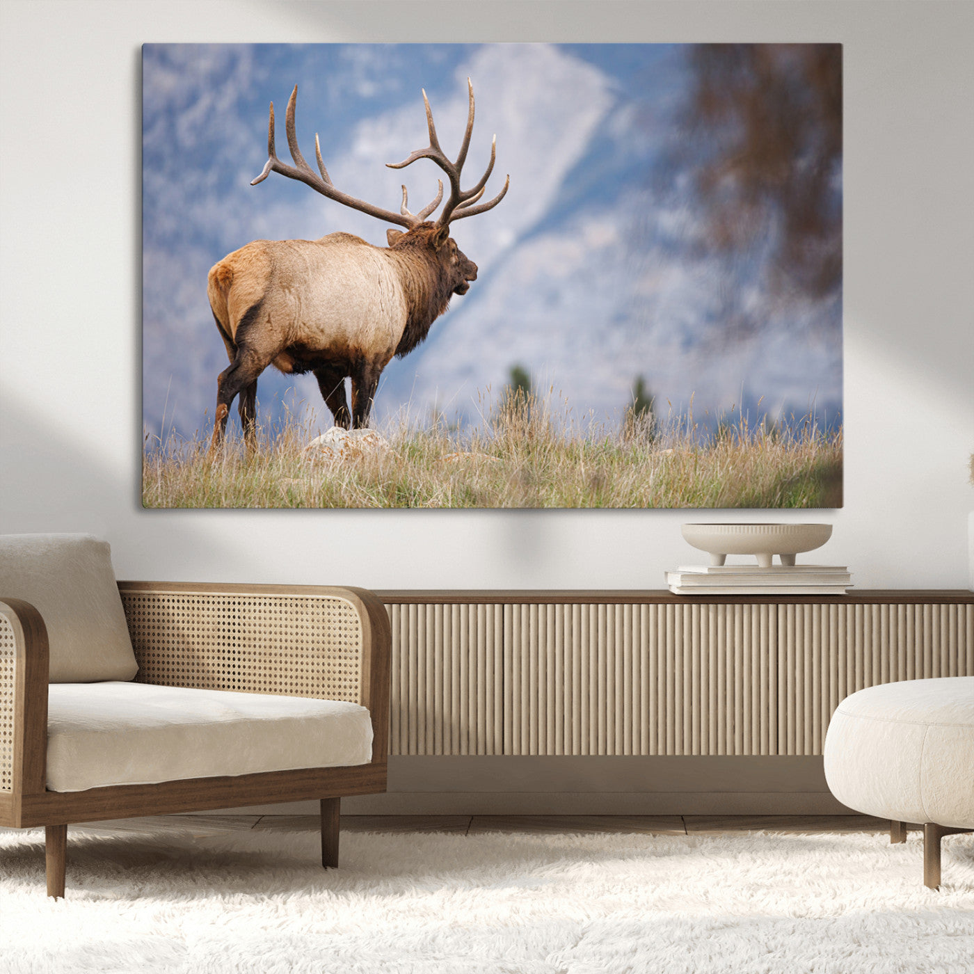 Elk with antlers standing on grass with mountain background, ideal for rustic, cabin, or lodge-inspired wall decor.
