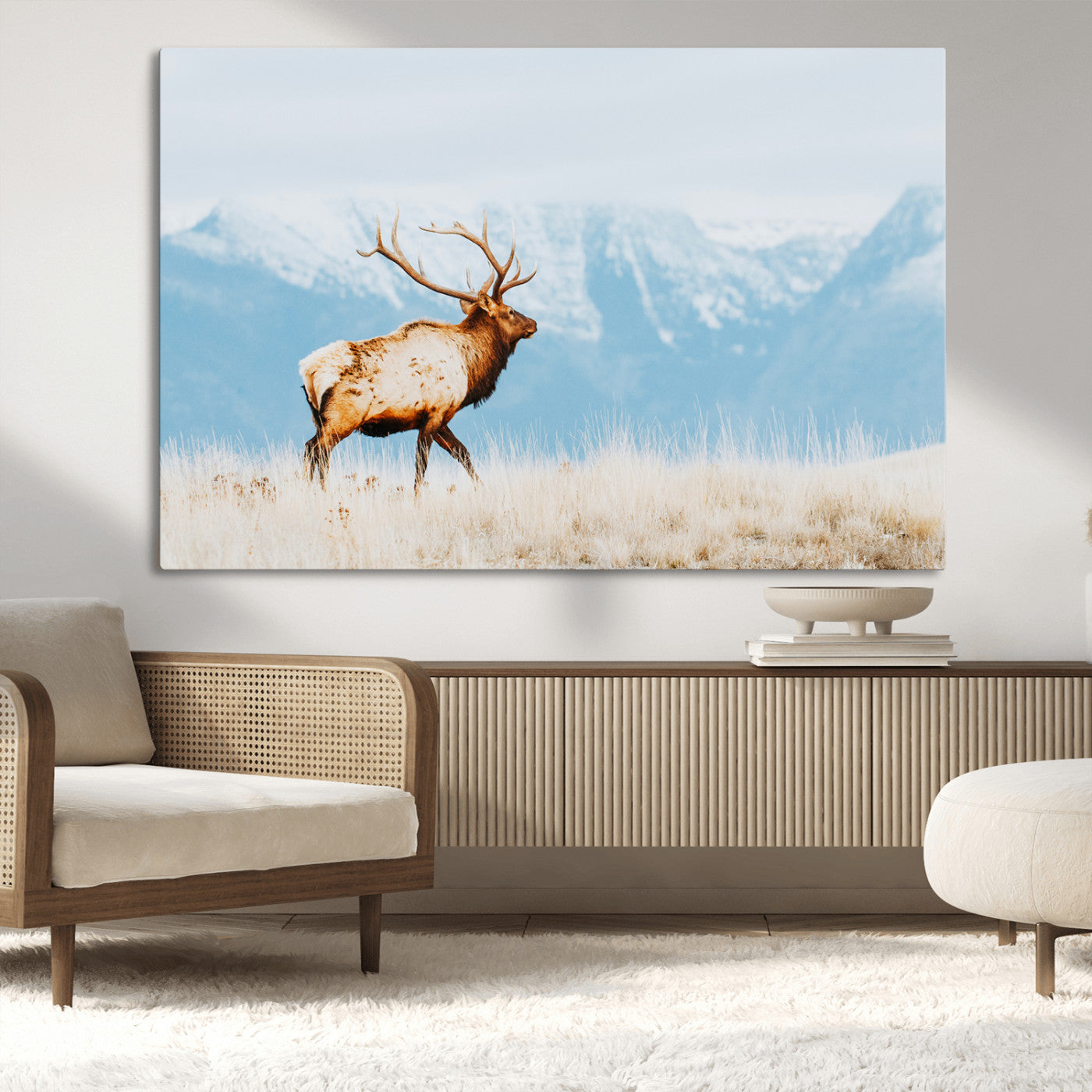 Majestic elk standing on dry grassland with snowy mountains in the background, ideal for rustic or lodge-inspired wall decor.
