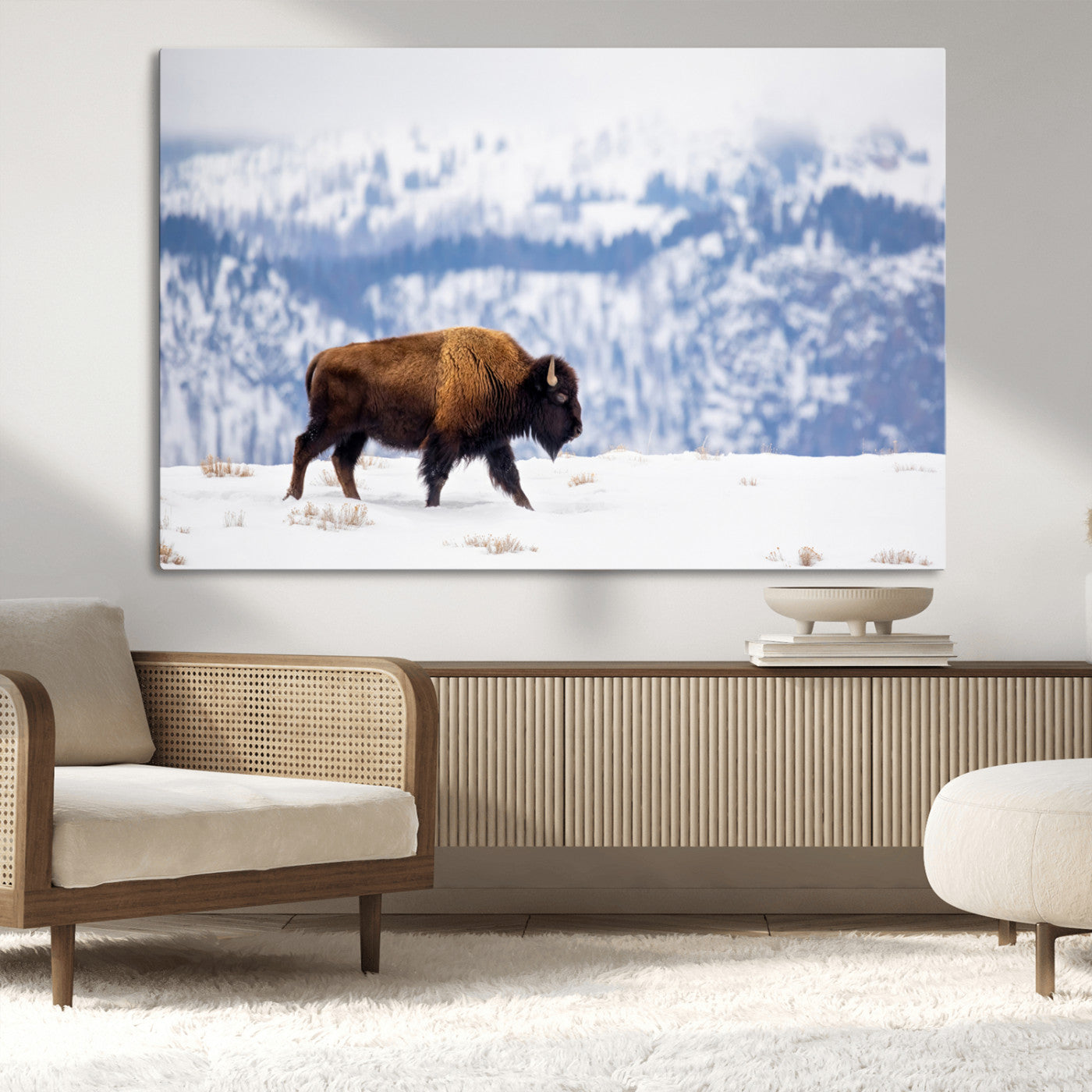 A lone bison walks across snowy ground with blue-toned mountain range behind, ideal for rustic or western farmhouse interiors.