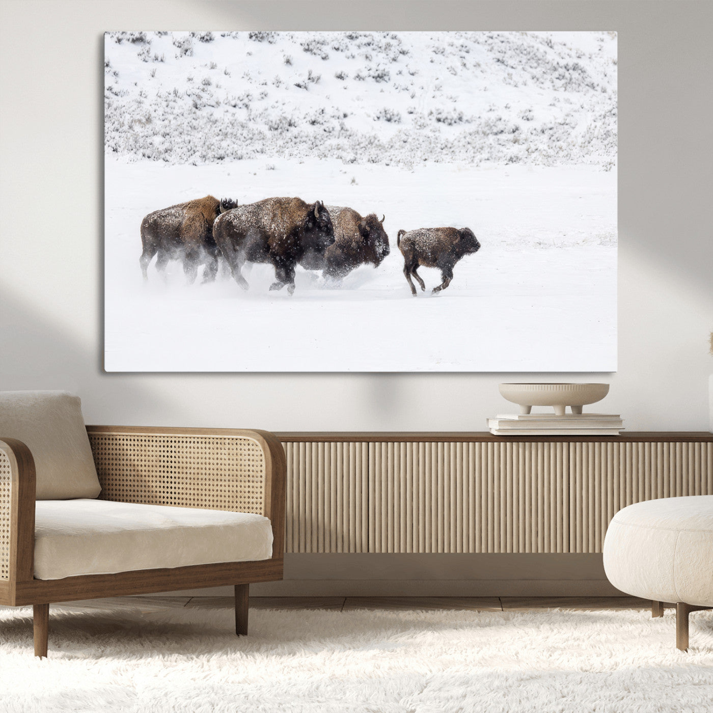 Bison herd running through a snowy open field with mountain backdrop, perfect for rustic or western-themed wall decoration.