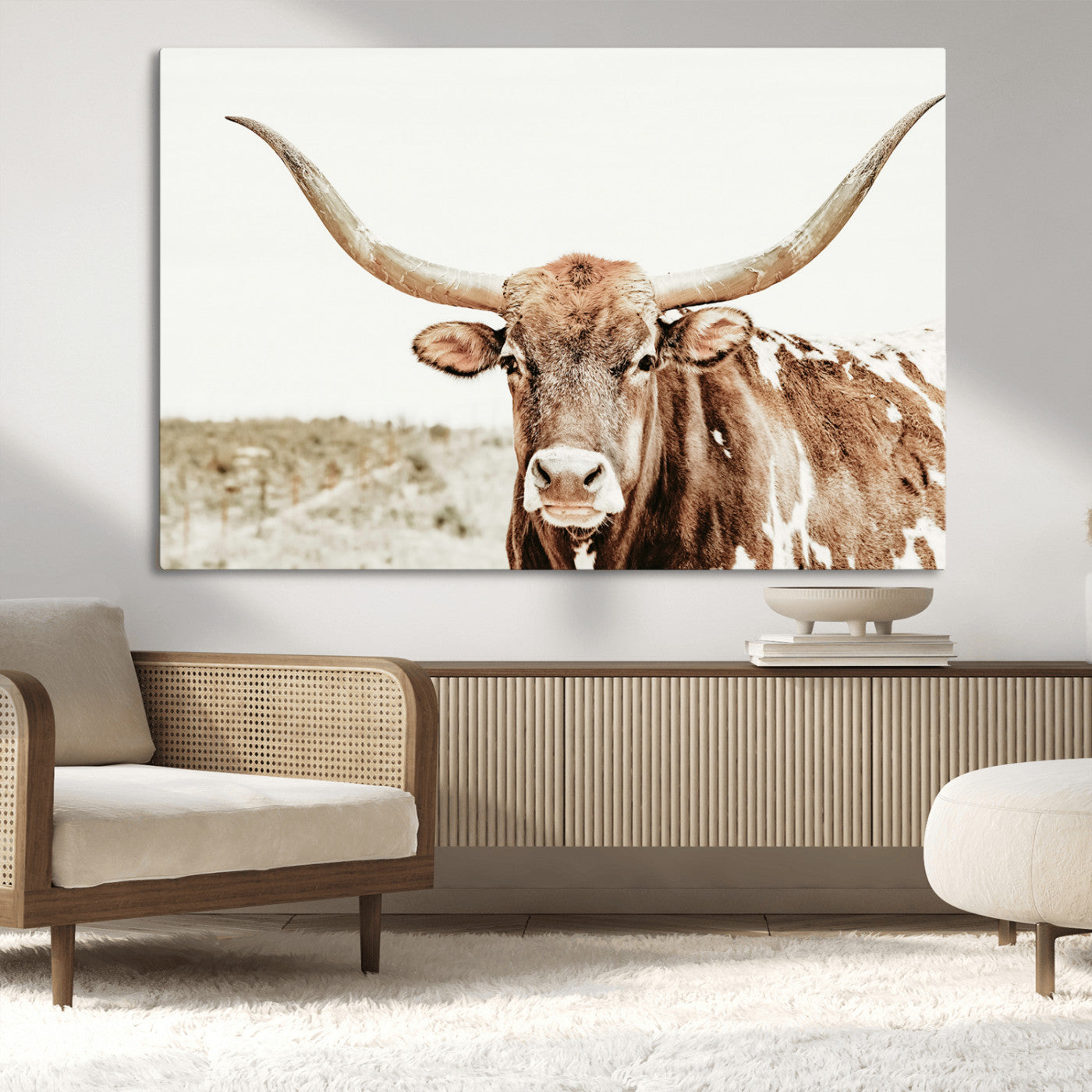 A Texas longhorn bull with wide horns, standing in a dry field under soft light, ideal for rustic farmhouse or western-themed interiors.