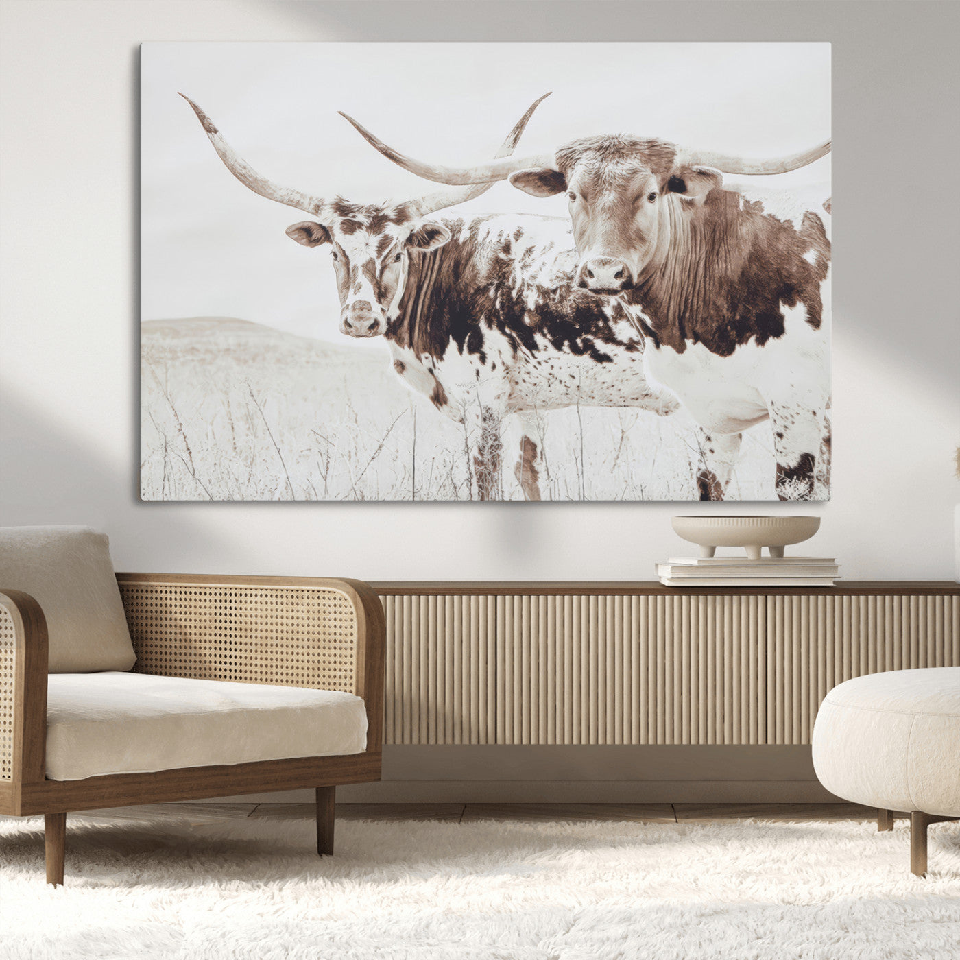 Two longhorn cattle standing in a dry grassy field with neutral tones, creating a rustic and farmhouse-inspired Western aesthetic.
