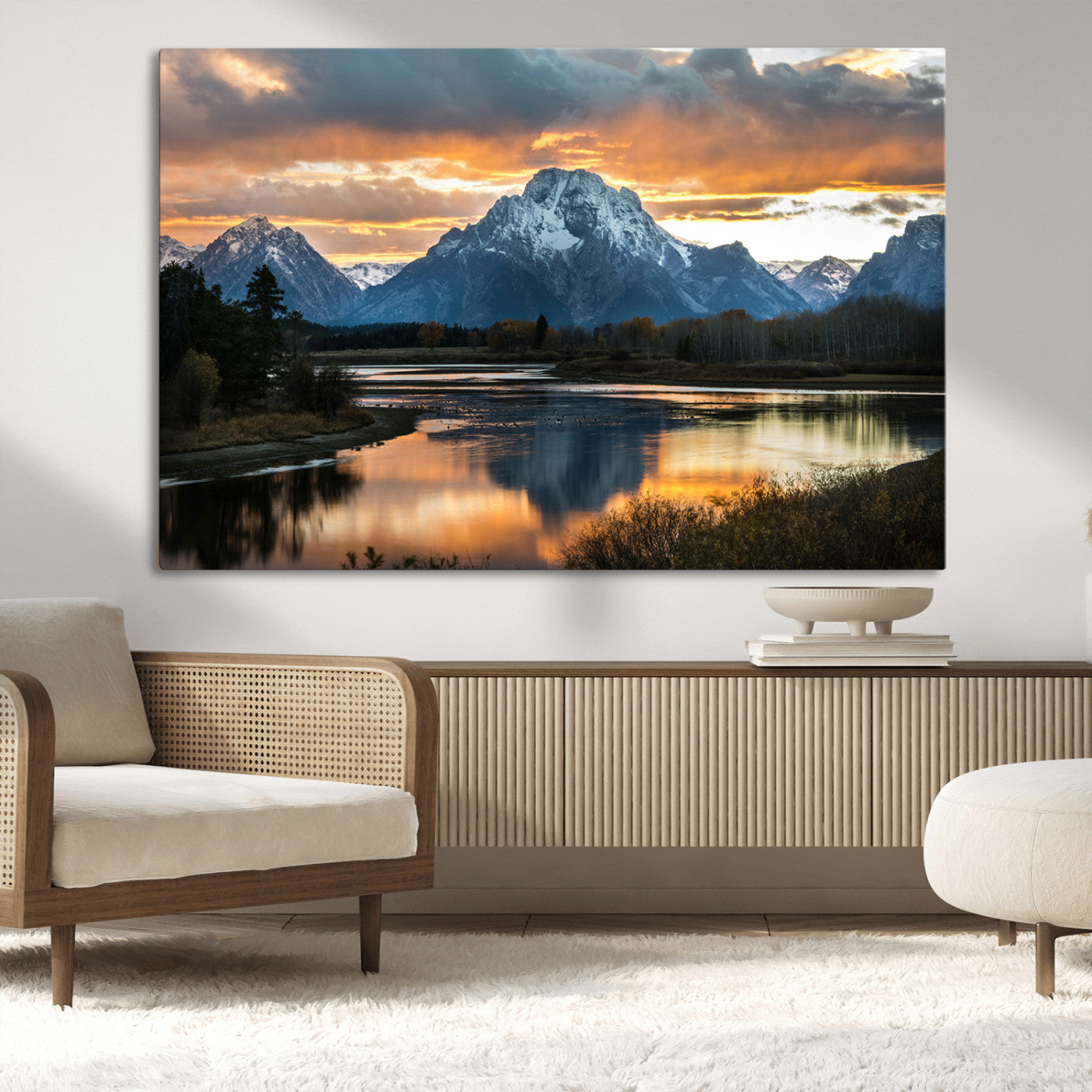 Snow-capped mountains reflecting in a calm lake at sunset, with a dramatic golden sky creating a breathtaking wilderness scene.
