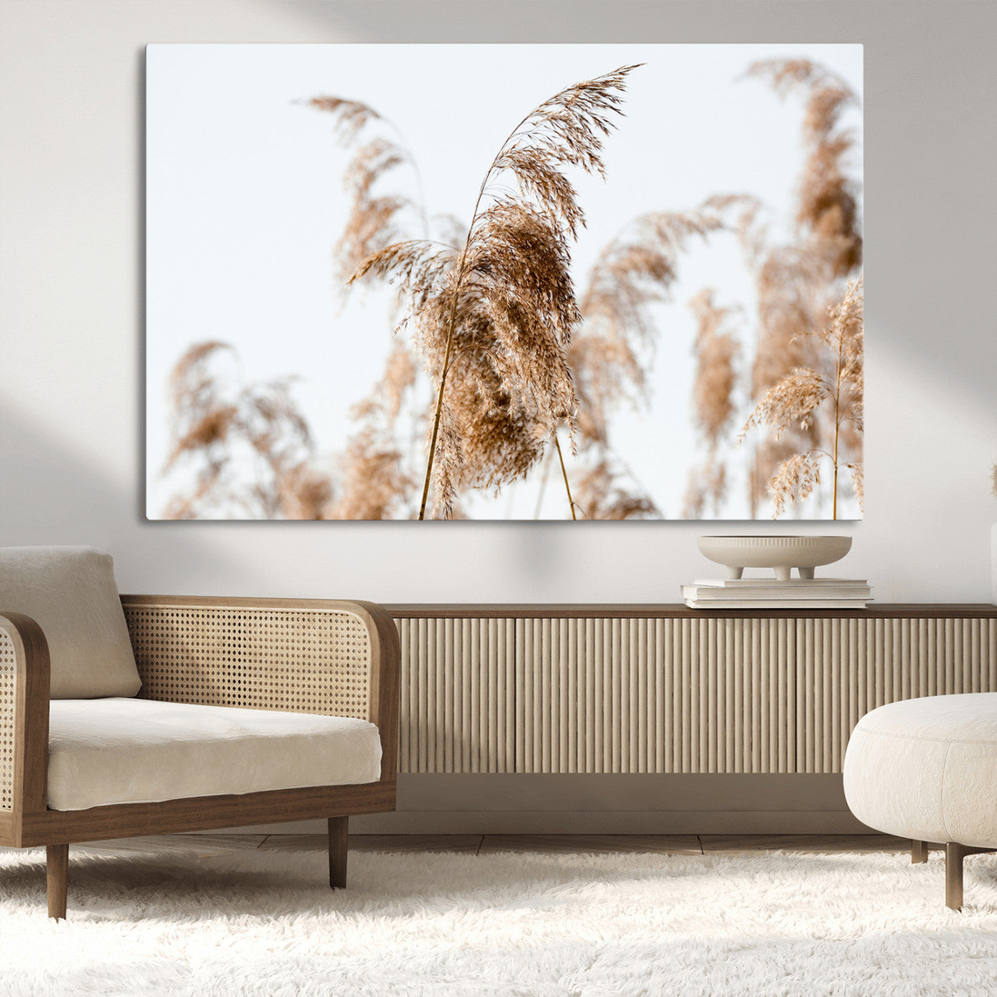 Close-up of pampas grass swaying in the wind against a soft white sky, creating a neutral and minimalist botanical aesthetic.