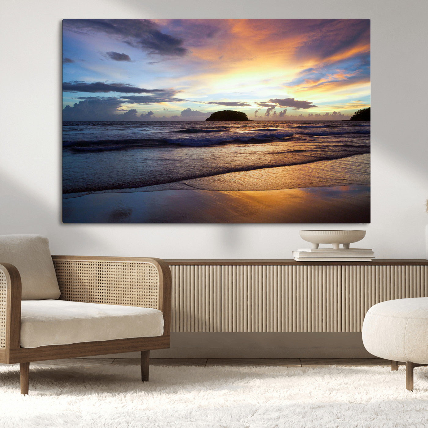 A tropical beach at sunset with waves gently washing ashore, reflecting golden and purple hues in the sky, creating a tranquil coastal scene.