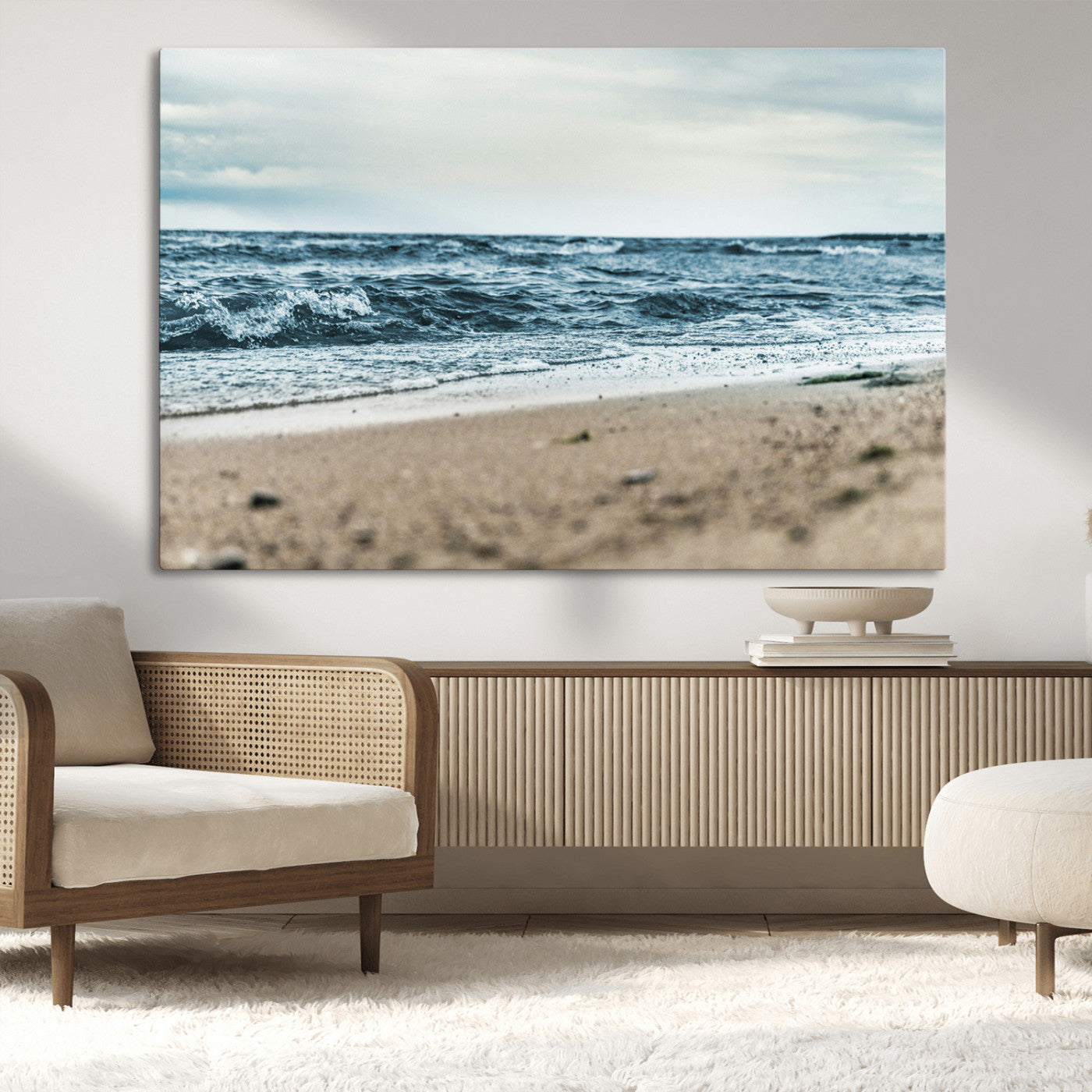 A moody ocean scene with gentle waves washing onto a sandy beach under a cloudy sky, creating a peaceful and coastal atmosphere.