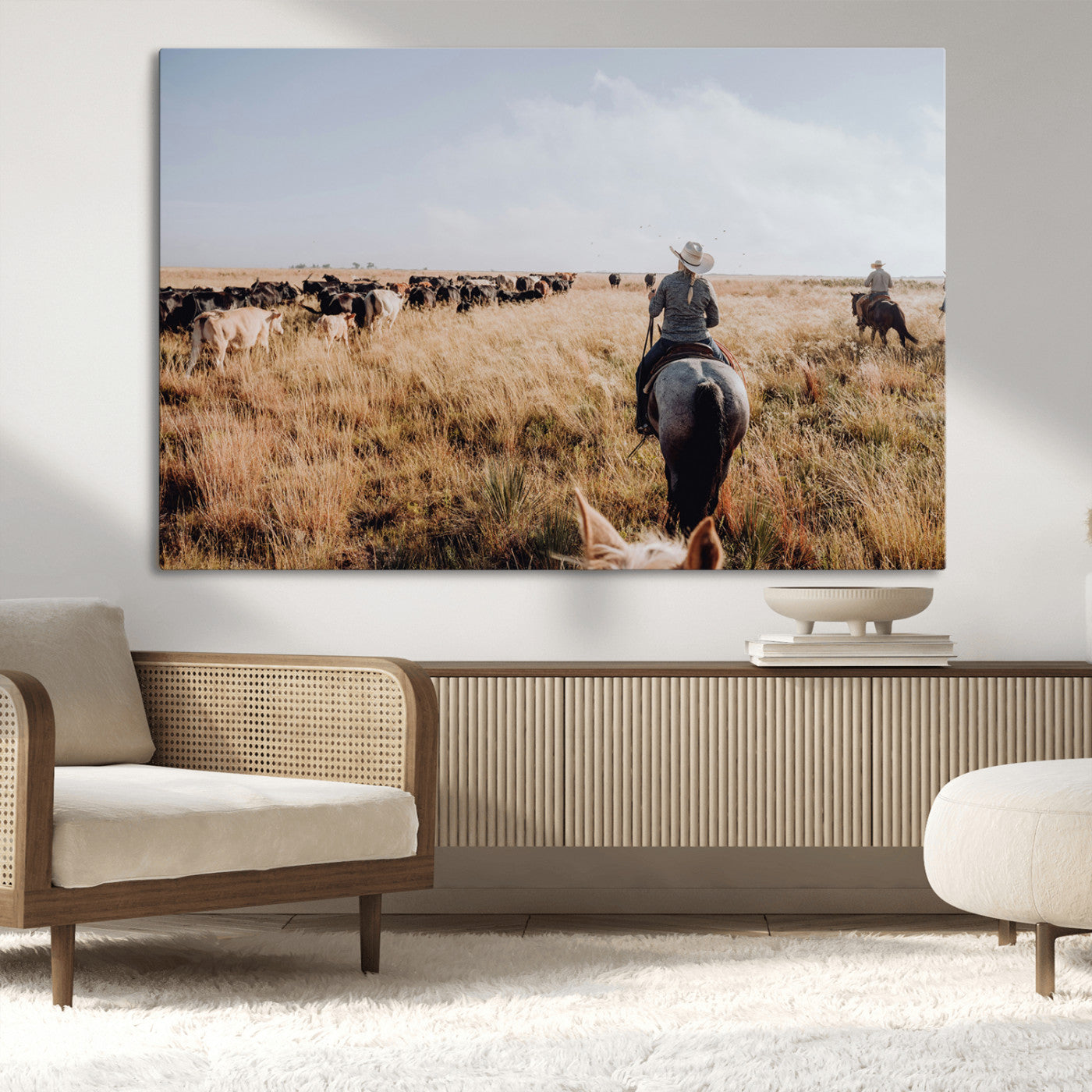 A cowboy and cowgirl on horseback herding cattle through golden grasslands, capturing a rustic and authentic Western ranch lifestyle.
