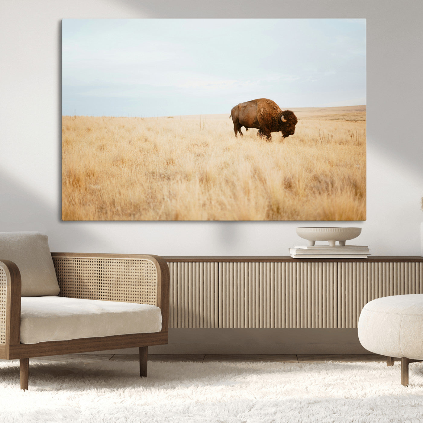 A lone bison standing in a vast golden grassland under a soft blue sky, evoking a rustic and Western aesthetic, ideal for farmhouse decor.