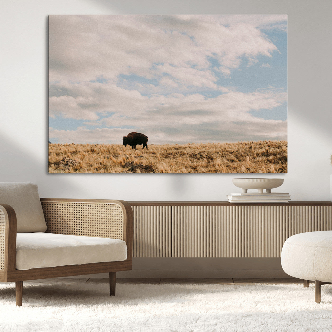 A solitary bison walking across a golden prairie under a vast, cloud-filled sky, evoking a peaceful, rustic western landscape for home decor.