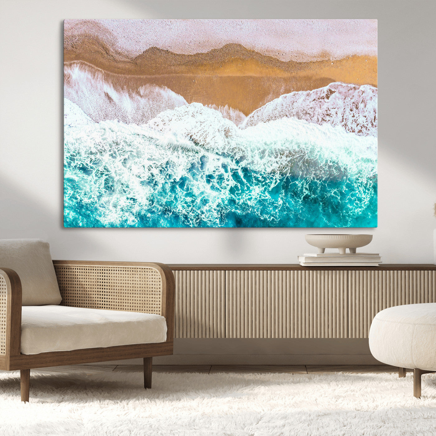 Aerial view of ocean waves crashing onto a sandy beach, with turquoise water and foamy white surf, creating a serene coastal aesthetic for home decor.