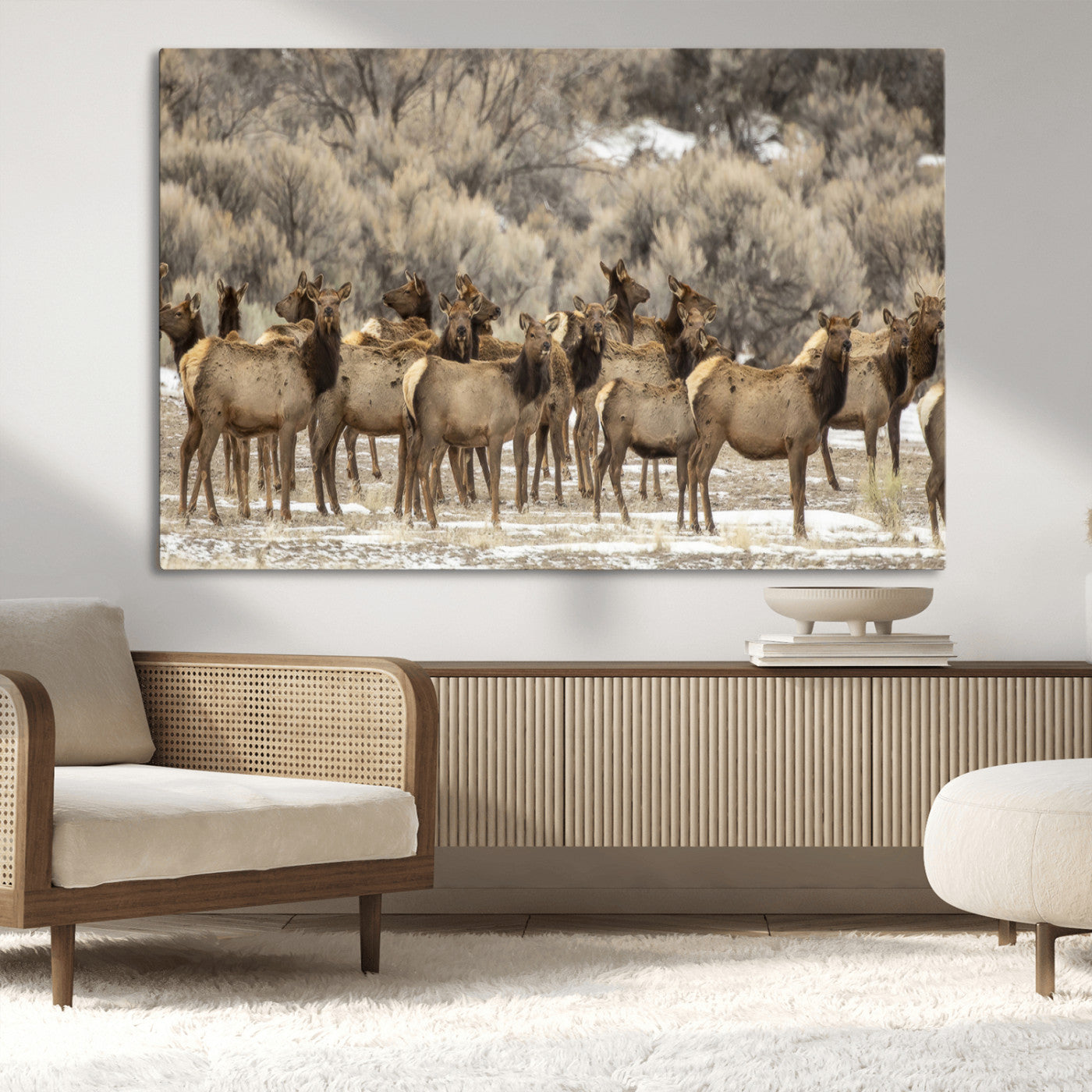 A stunning wall art canvas print featuring a large herd of elk standing together in a natural winter landscape with muted earthy tones and soft background foliage, perfect for rustic or nature-inspired home decor.