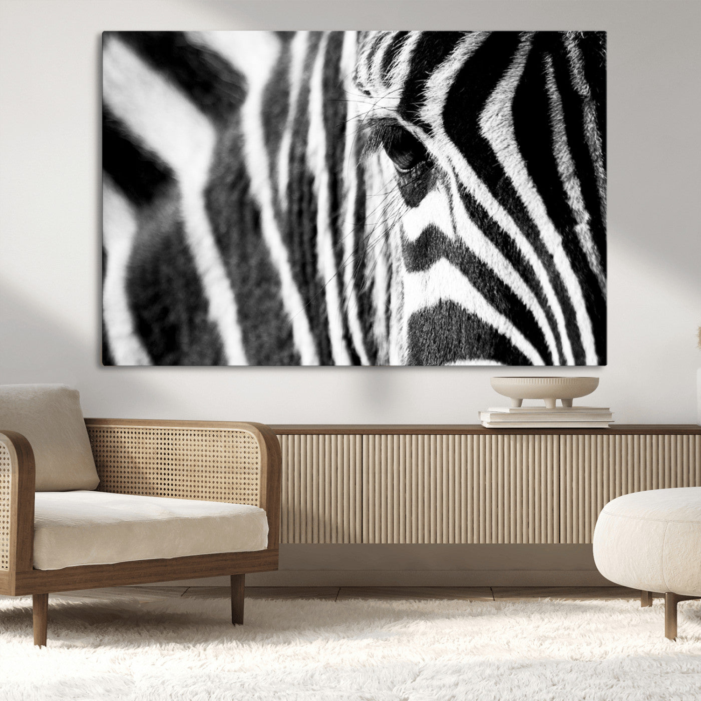 A close-up black and white photograph of a zebra's eye, showcasing the intricate patterns of its stripes in sharp detail.