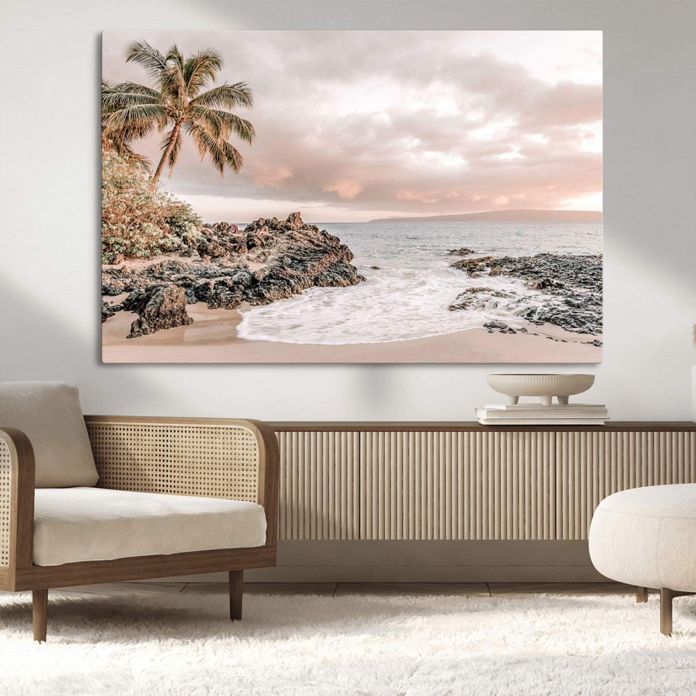 A peaceful beach scene with a palm tree and rocks, soft waves washing onto the shore under a soft pastel sky at sunset.