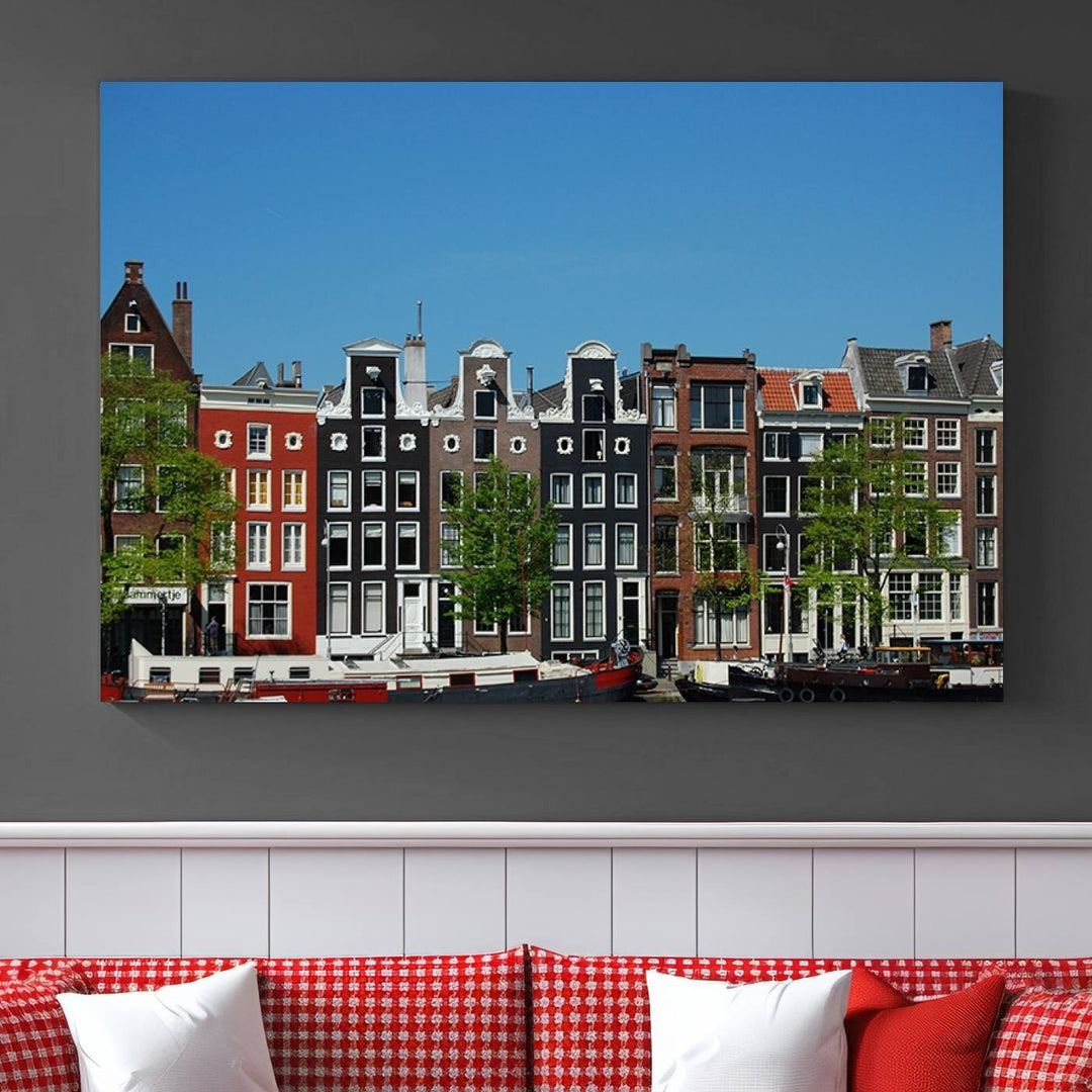 The Amsterdam City Wall Art Canvas Print showcases colorful traditional canal houses and boats set against a clear blue sky.