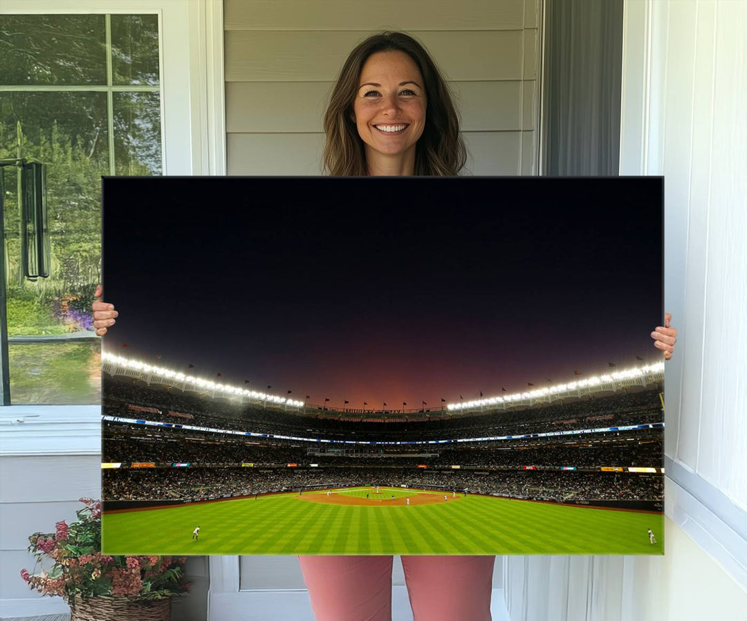 A night game at Yankee Stadium depicted on canvas beneath a sunset sky.