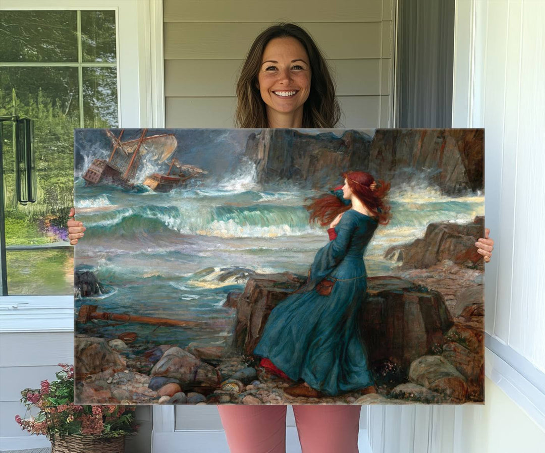 Miranda - The Tempest Canvas Print depicts a woman in a blue dress gazing at a shipwreck on a rocky shore. The artwork is ready to hang.