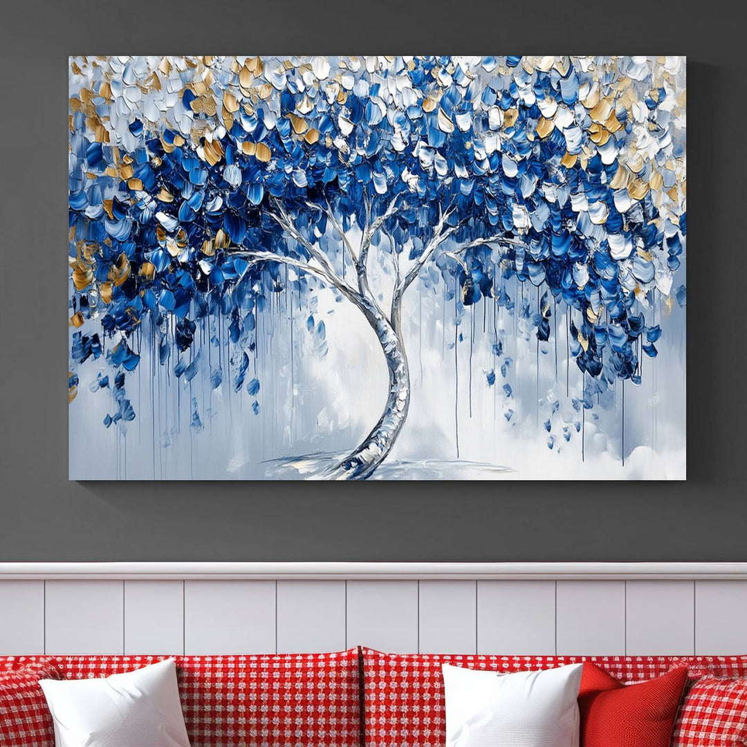 The Blue and Gold Abstract Tree Wall Art showcases a swirl trunk and features blue, silver, and gold leaves on a framed canvas print.