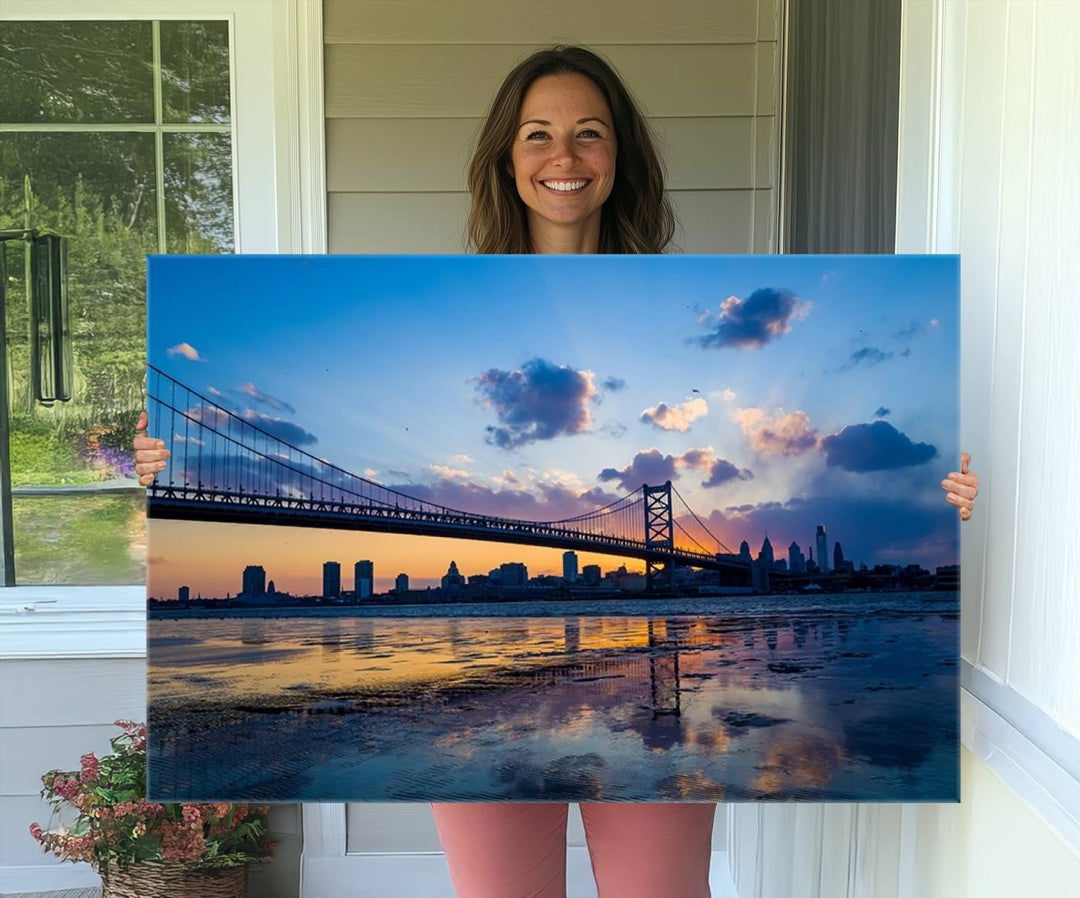 A photograph titled "Large Wall Art Philadelphia Canvas Print - Benjamin Franklin Bridge at Sunset" displays a breathtaking cityscape of the bridge reflected in the water. This image features a gallery-quality finish that promises to transform any space into an evocative memory.