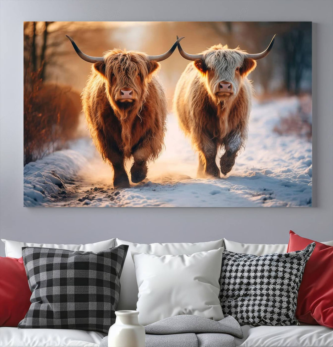 The wall art is a Scottish Highland Cow Horn canvas print featuring cows on a snowy path bathed in warm sunlight, serving as a rustic decor piece.