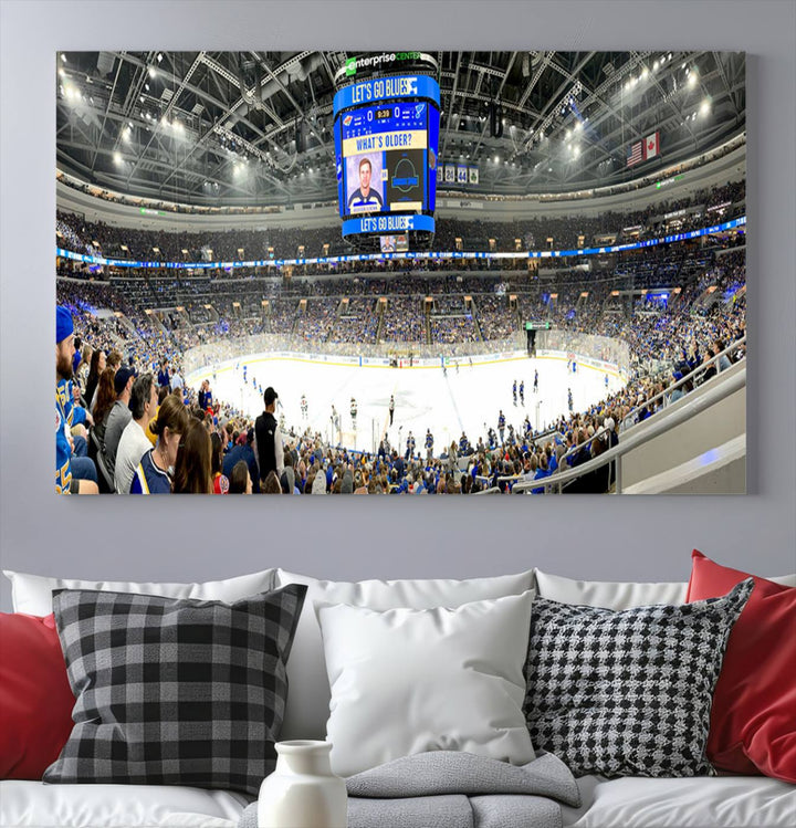 Wall art prints depicting the bustling scenes of the St. Louis Blues being cheered on by a full house at the Enterprise Center, beneath a large scoreboard.